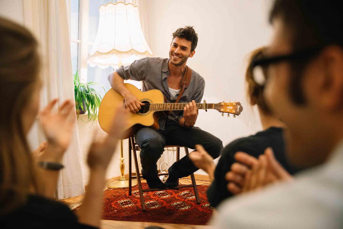 Musiker spielt Gitarre auf Wohnzimmerkonzert