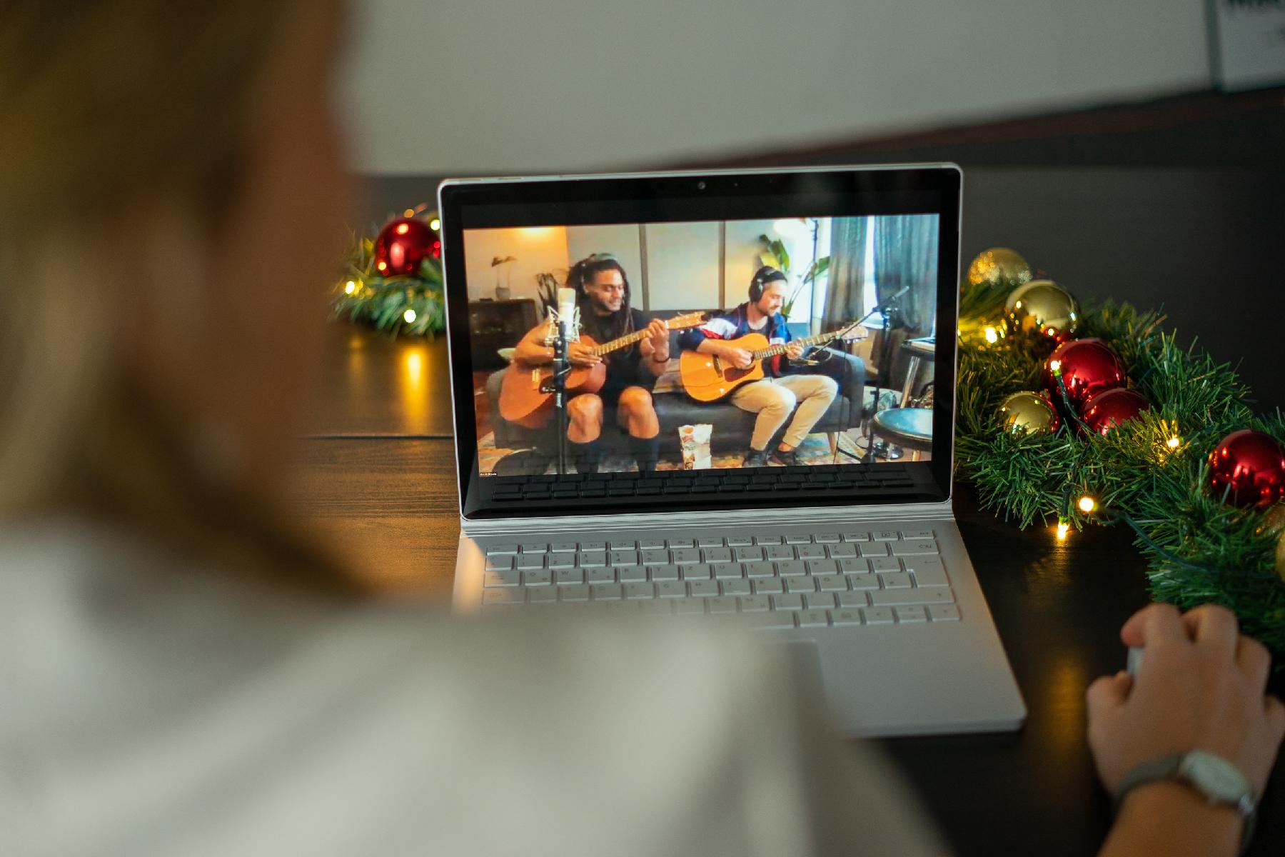 Mitarbeiterin sieht Livestream Konzert einer virtuellen Weihnachtsfeier